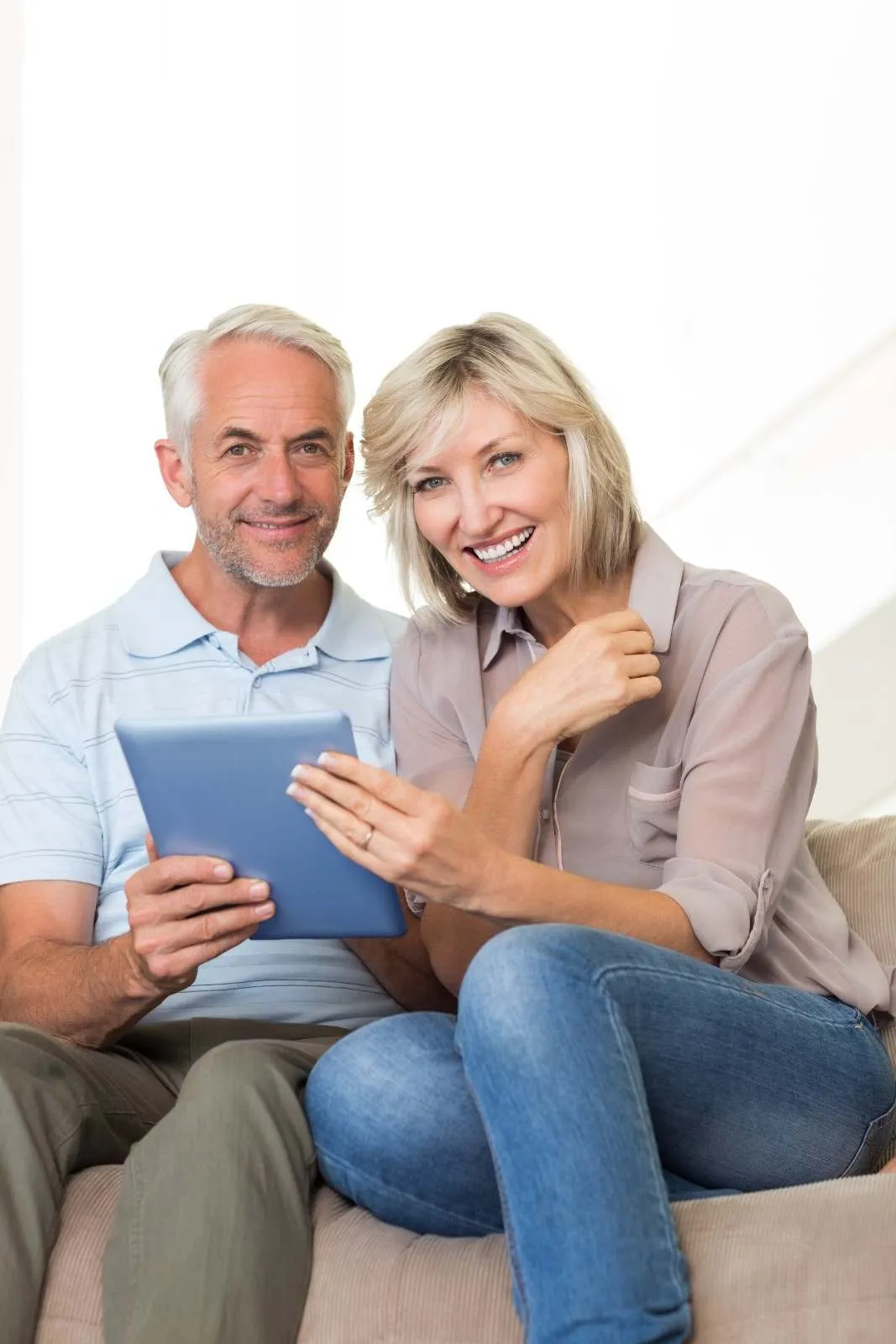 Couple on a sofa going through a Medicare review together on a tablet